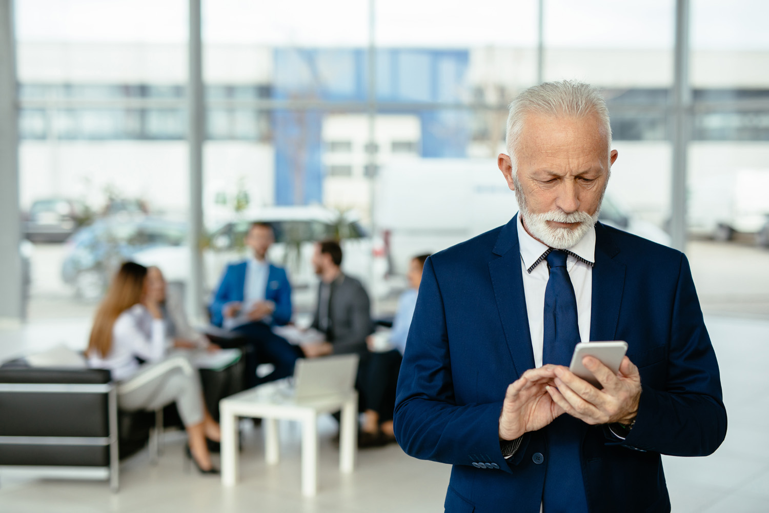 Business owner checks his mobile for messages.