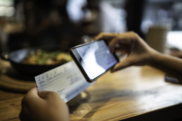 Credit union member deposits a cheque by taking a photo with a smartphone.