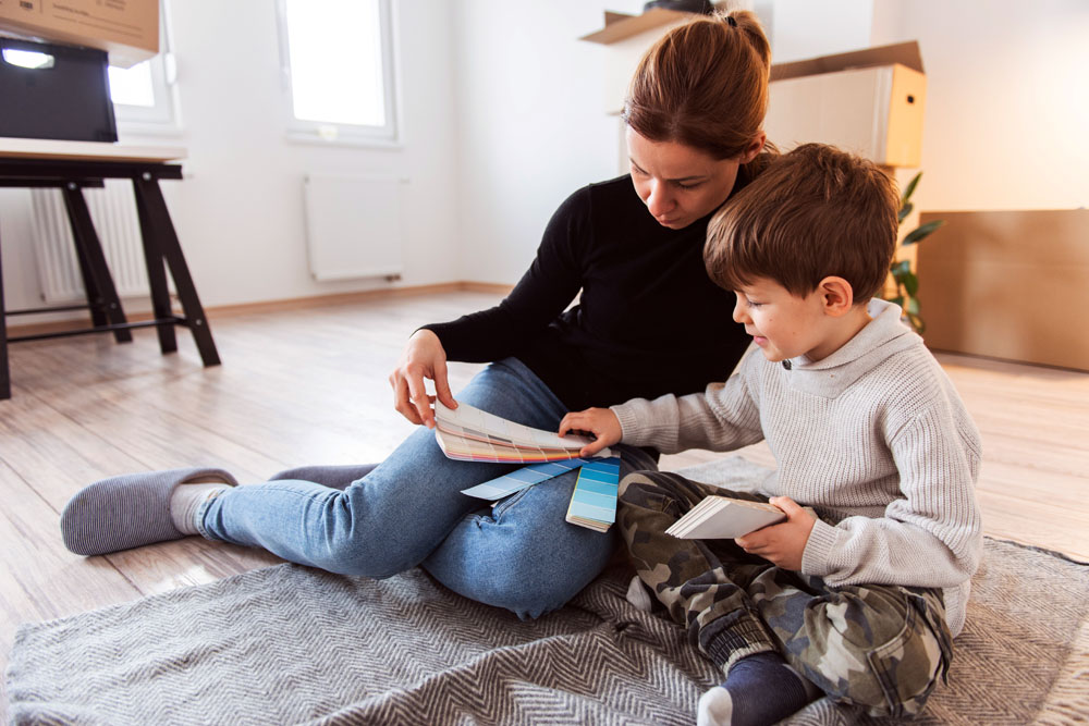 Mother and son pick out paint colour in new home.