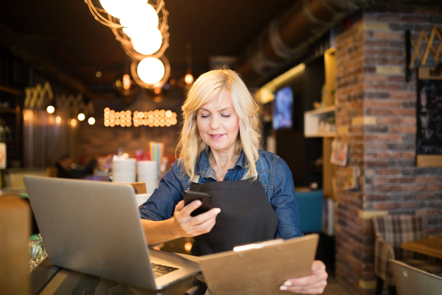 Restaurant owner checks her phone for messages.