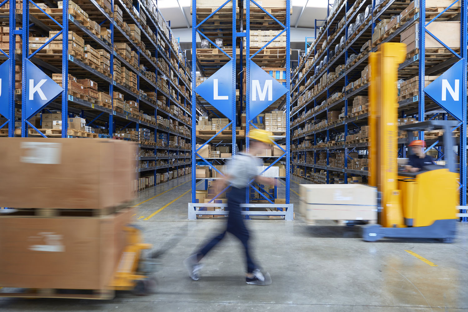 Worker uses forklift to move heavy materials in warehouse.